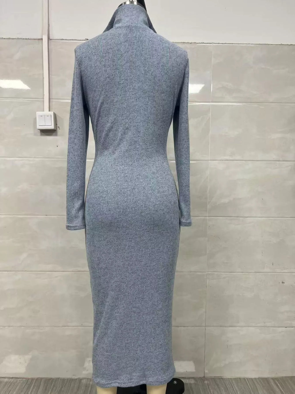 Vue arrière d'une robe tricotée côtelée bleu-gris clair sur mannequin affichant motif de côtes verticales continues et coupe ajustée