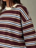 Close-up of maroon striped t-shirt with light blue and beige bands highlighting soft fabric texture and relaxed shoulder seam