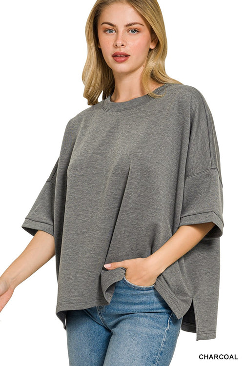 Side view of charcoal grey relaxed fit blouse showing hem slits and loose drape at waist