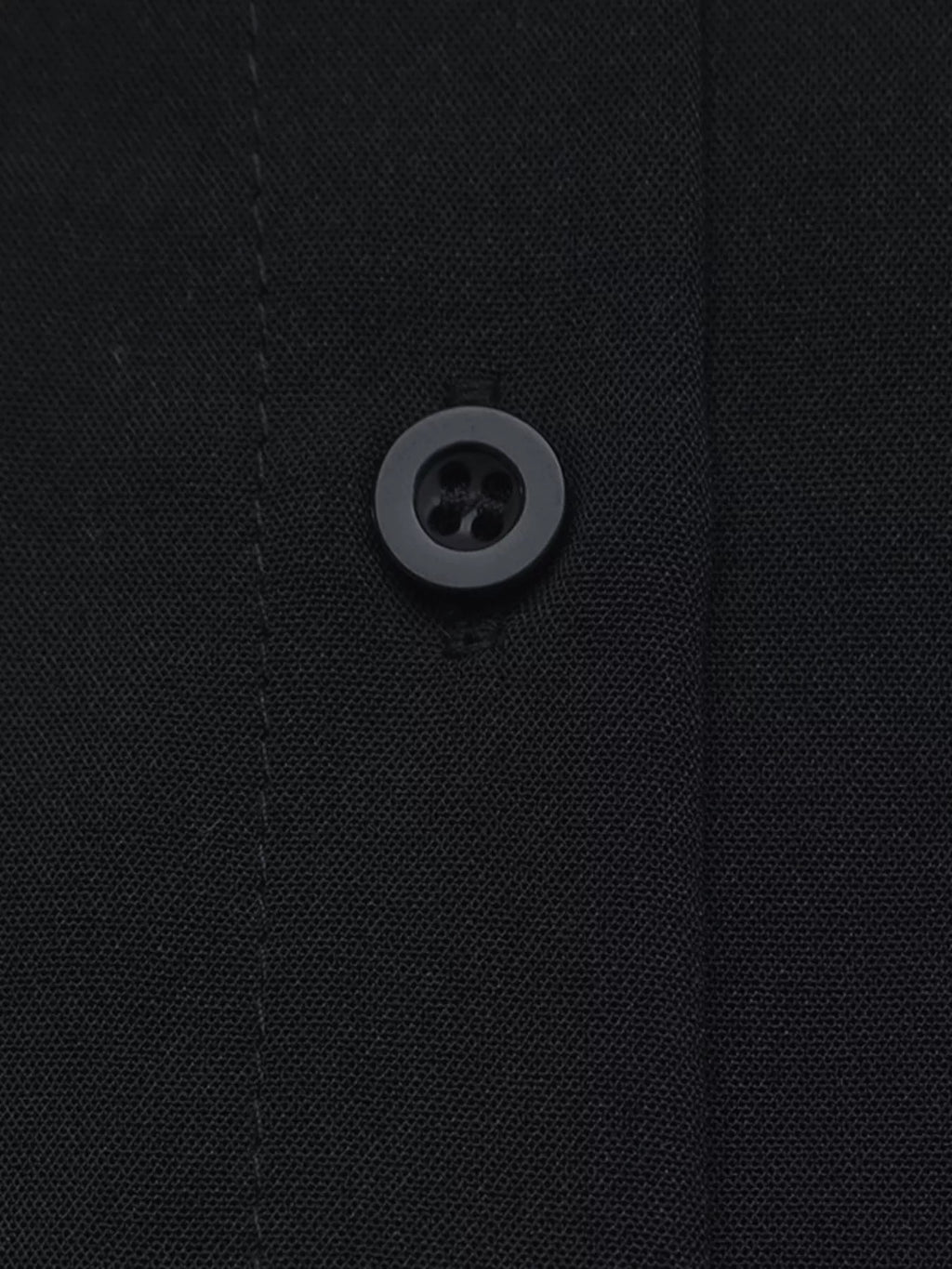 Macro texture tissu polyester noir et unique bouton mat quatre trous sur patte