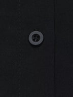 Macro texture tissu polyester noir et unique bouton mat quatre trous sur patte