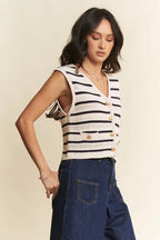 Side profile showing cropped hemline and deep armholes of navy cream striped vest worn over dark wash denim