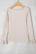 Flat lay of beige ribbed top on hanger displaying boat neck and lace patchwork