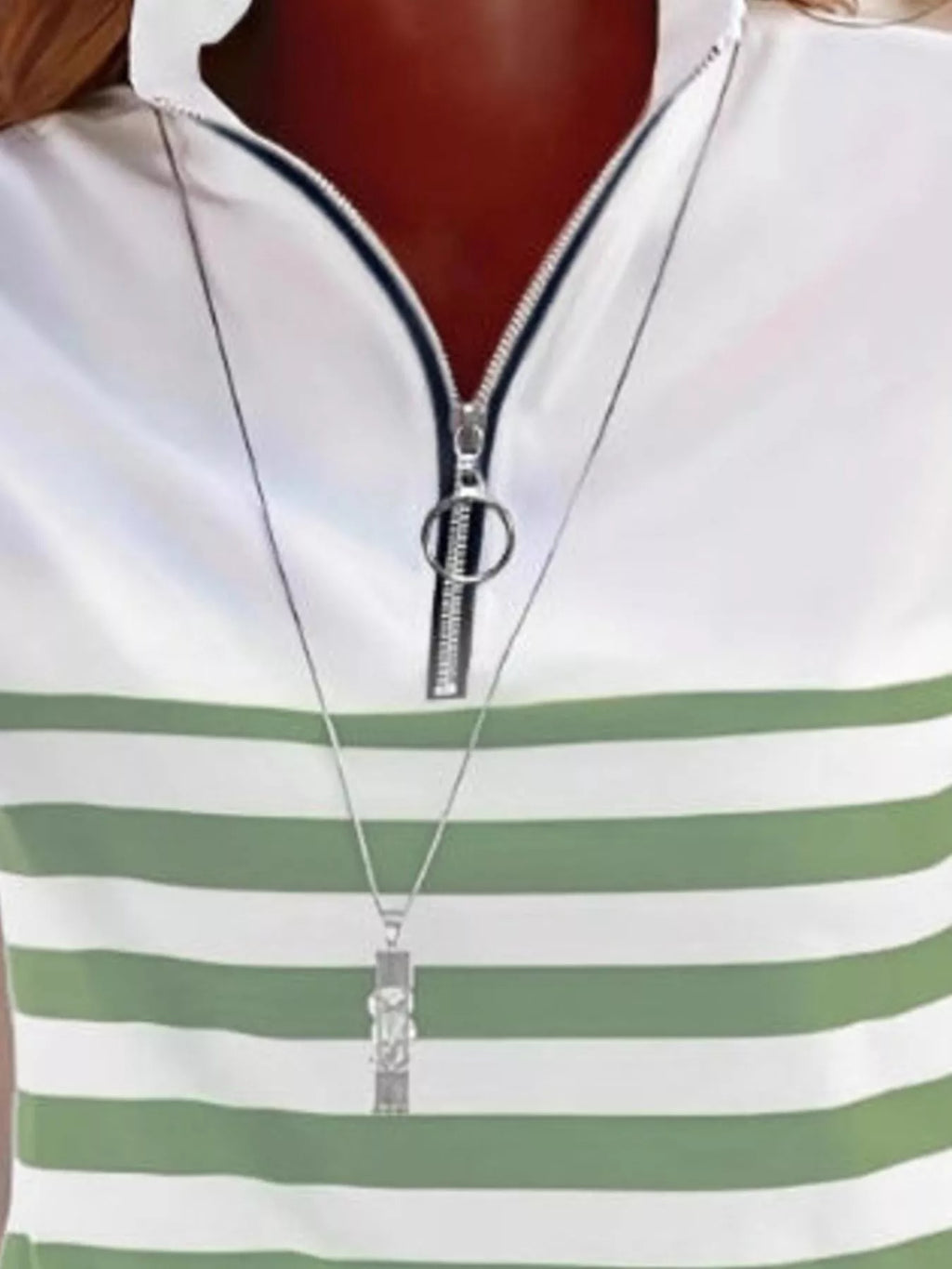 Macro shot of green and white striped neckline showing silver zipper mechanism