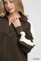 Close-up of textured fabric, V-neck stitching, and brown cream color block contrast
