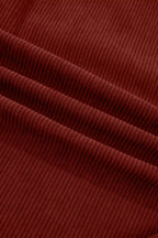 Macro of rich burgundy corduroy material showing vertical wale pattern and drape