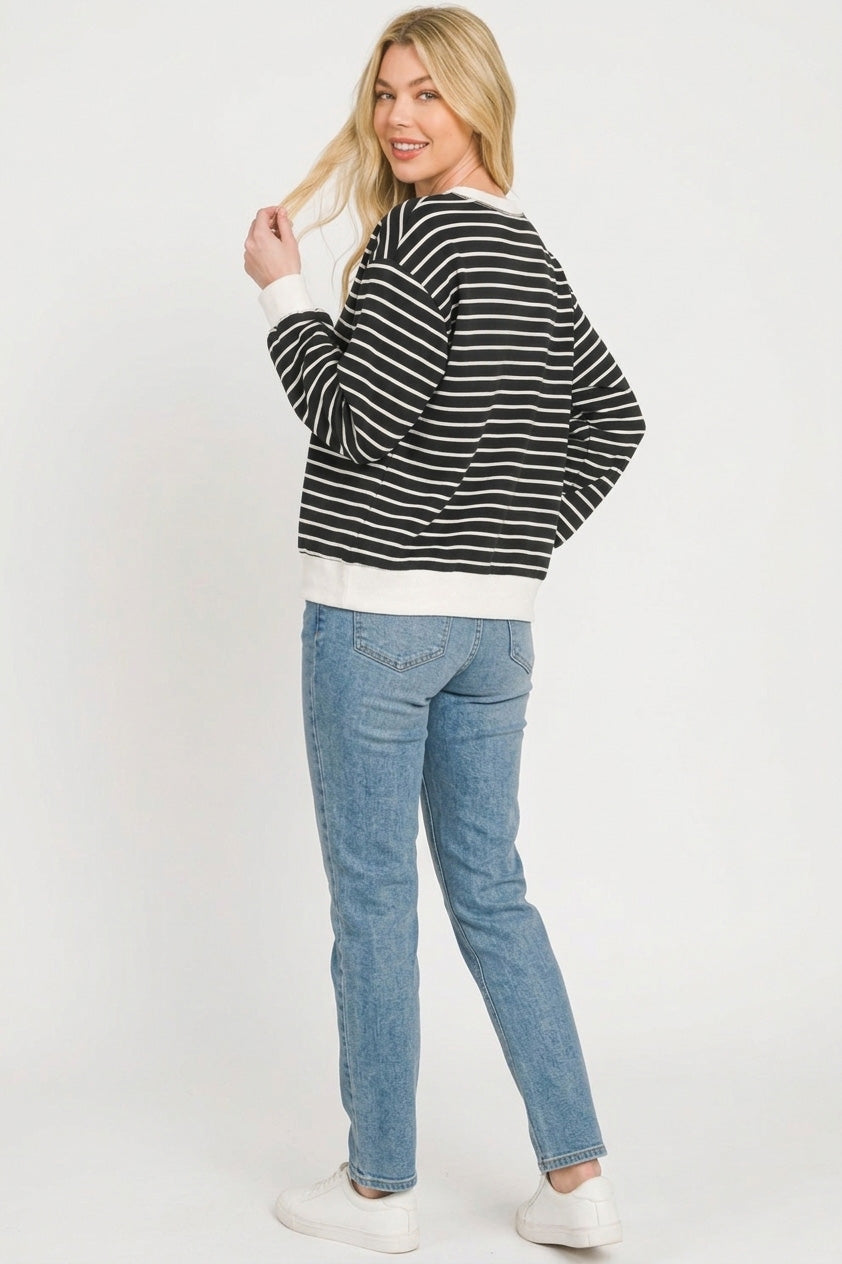 Rear three-quarter view of black and white striped pullover showing consistent horizontal stripes and loose silhouette over