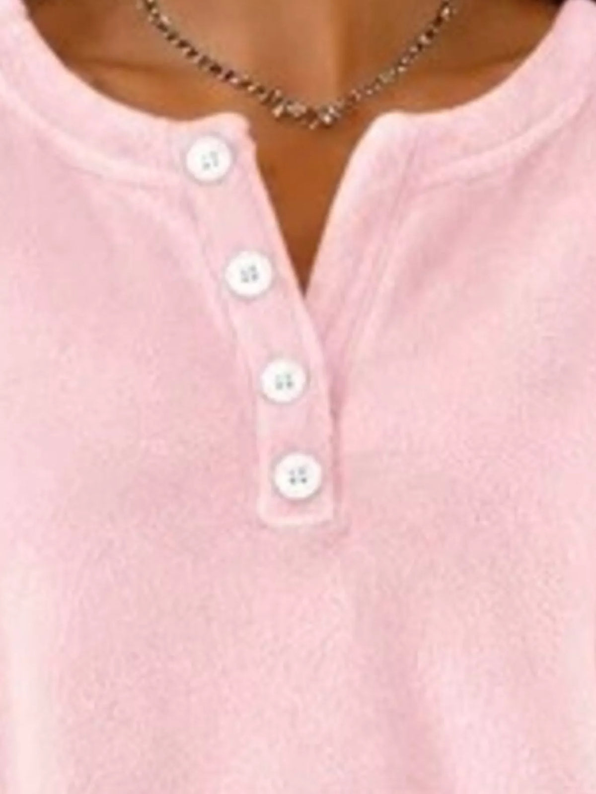 Pink sweatshirt chest detail focusing on ribbed collar trim and four-button placket