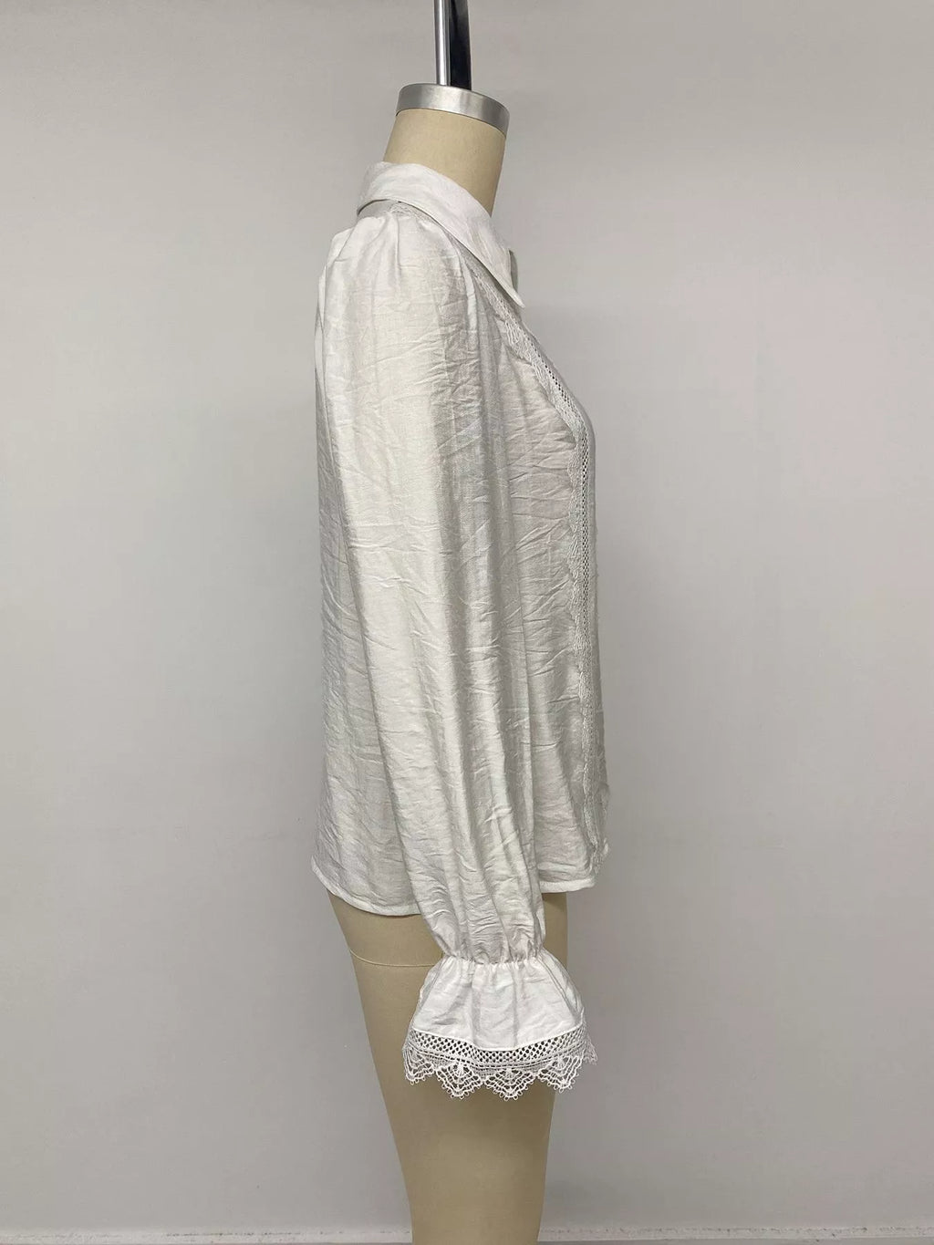 Seitenprofil weißes Shirt am Mannequin, hebt strukturierte gekräuselte Viskose und gerüschte Bündchen mit Spitze hervor.