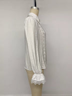 Seitenprofil weißes Shirt am Mannequin, hebt strukturierte gekräuselte Viskose und gerüschte Bündchen mit Spitze hervor.