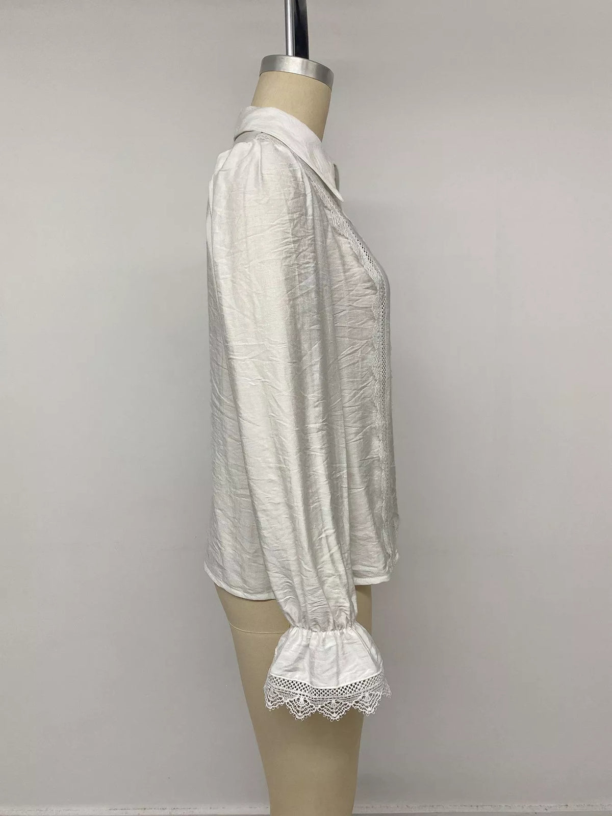 Seitenprofil weißes Shirt am Mannequin, hebt strukturierte gekräuselte Viskose und gerüschte Bündchen mit Spitze hervor.