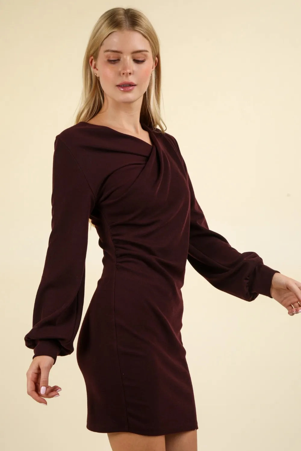 Side profile of figure-hugging burgundy dress highlighting sculpting ruched waist detail