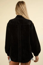 Rear view of oversized black shacket showing drop shoulders, velvet texture, and curved raw hemline