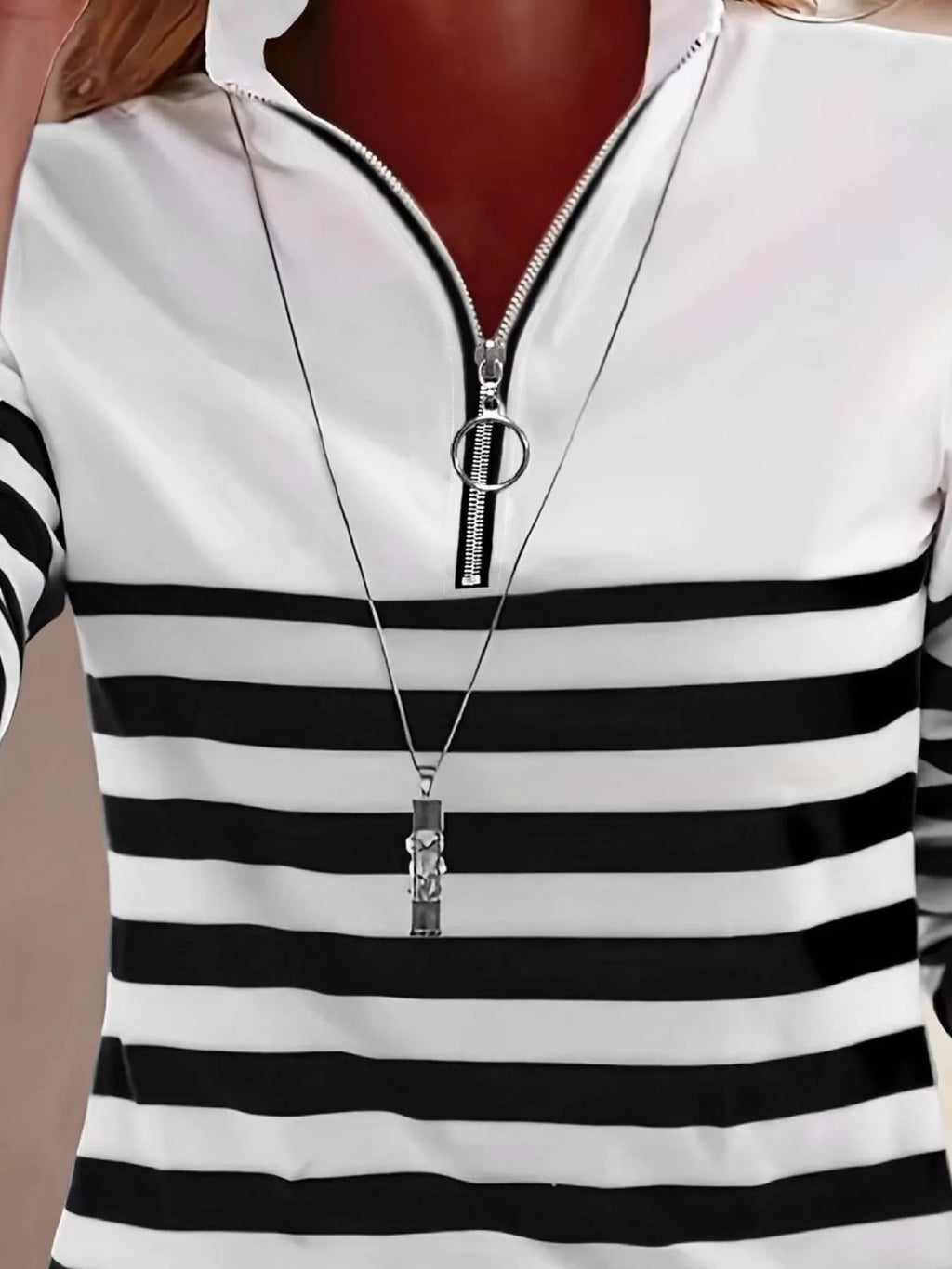 Close-up of silver ring pull zipper on black and white striped polyester top