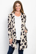 Model in beige leopard print cardigan with black and purple spots, white top, blue jeans, showing relaxed fit and side