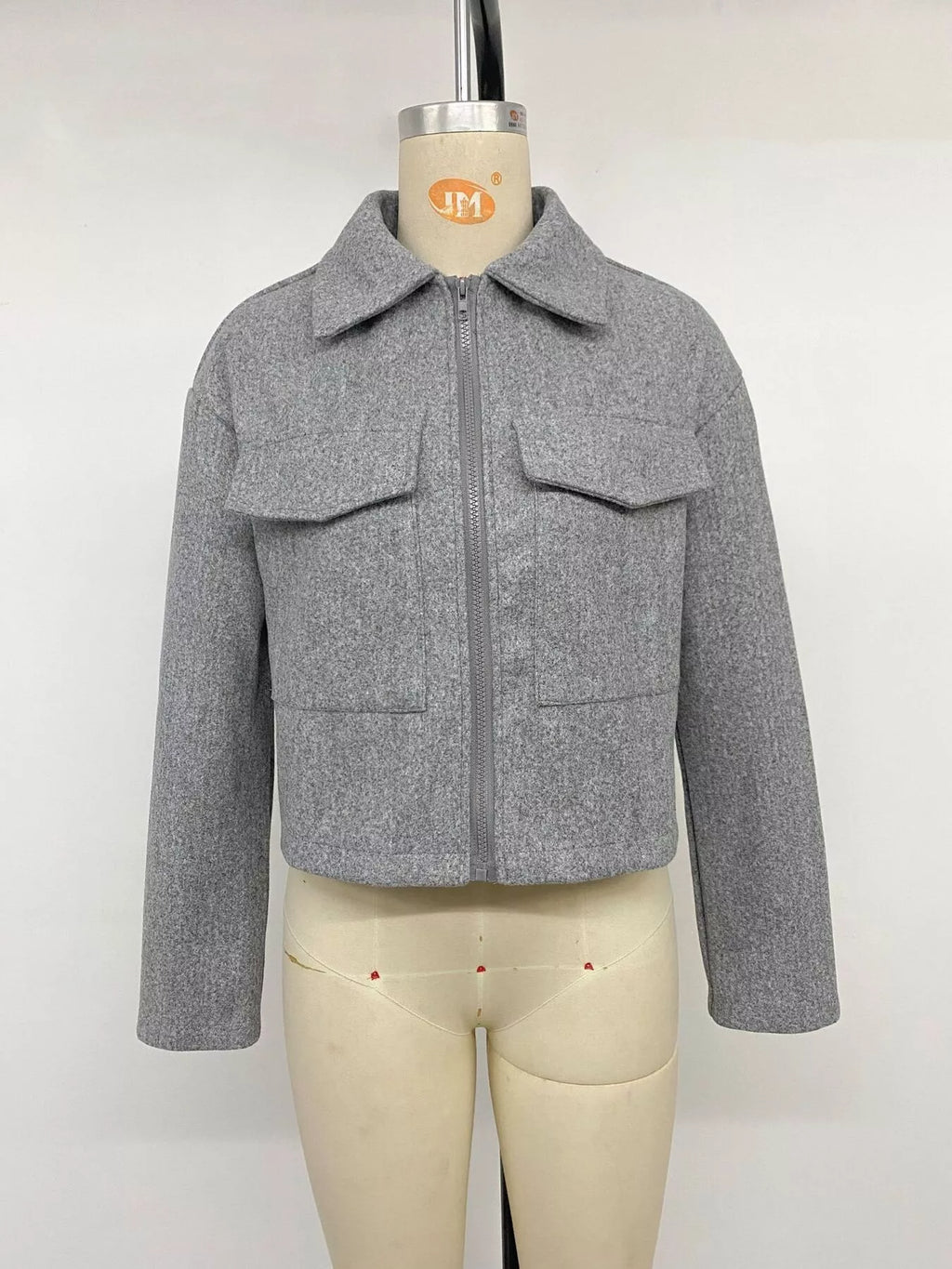 Frontalproduktshot der grauen Perfee Jacke am Mannequin mit geschlossenem Zentralreißverschluss, symmetrischen Klappentaschen und strukturierter Form