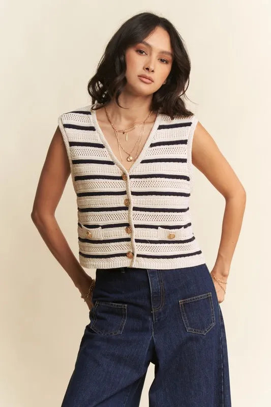 Frontal view of sleeveless cropped striped sweater vest paired with dark blue wide-leg denim jeans in studio