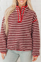 Modelo con sudadera fuzzy roja y crema a rayas horizontales, cuello alto acanalado rojo brillante