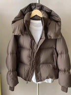 Brown quilted hooded puffer jacket hanging open on hanger displaying diamond-stitched inner placket