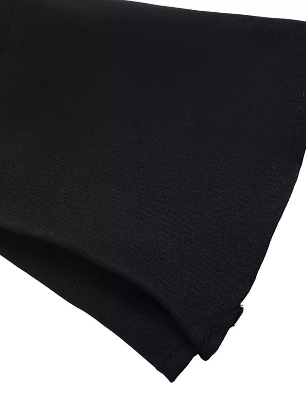 Macro ourlet tissu noir : bordure propre et drapé léger doux contre fond blanc