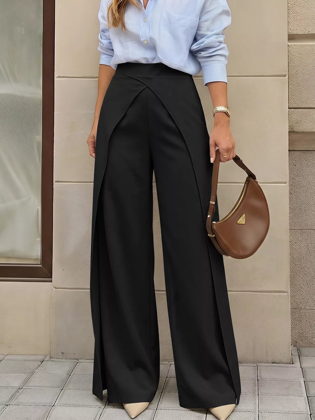 Model wearing black high-rise trousers with asymmetrical waist against beige background