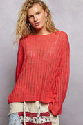 Coral-red open weave sweater with vertical ribbed texture and wide boat neckline against grey background