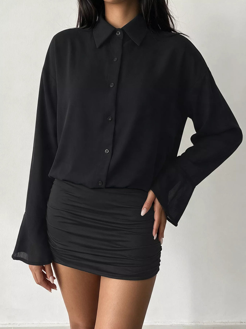 Mannequin robe mini noire à boutons, col pointu, poignets cloche translucides et juane froncée fond blanc