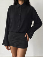 Mannequin robe mini noire à boutons, col pointu, poignets cloche translucides et juane froncée fond blanc