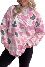 Model wearing pink grey abstract camo sweatshirt with white Howdy script and black leggings