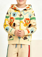 Nahaufnahme von leuchtend orangen Löwen und blauen Koalas auf beigem Hoodie, Hände gefaltet