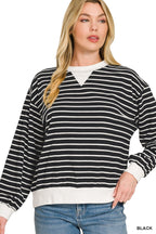 Close-up of black and white striped sweatshirt with crew neck, white V-panel, ribbed cuffs, and hem against white background
